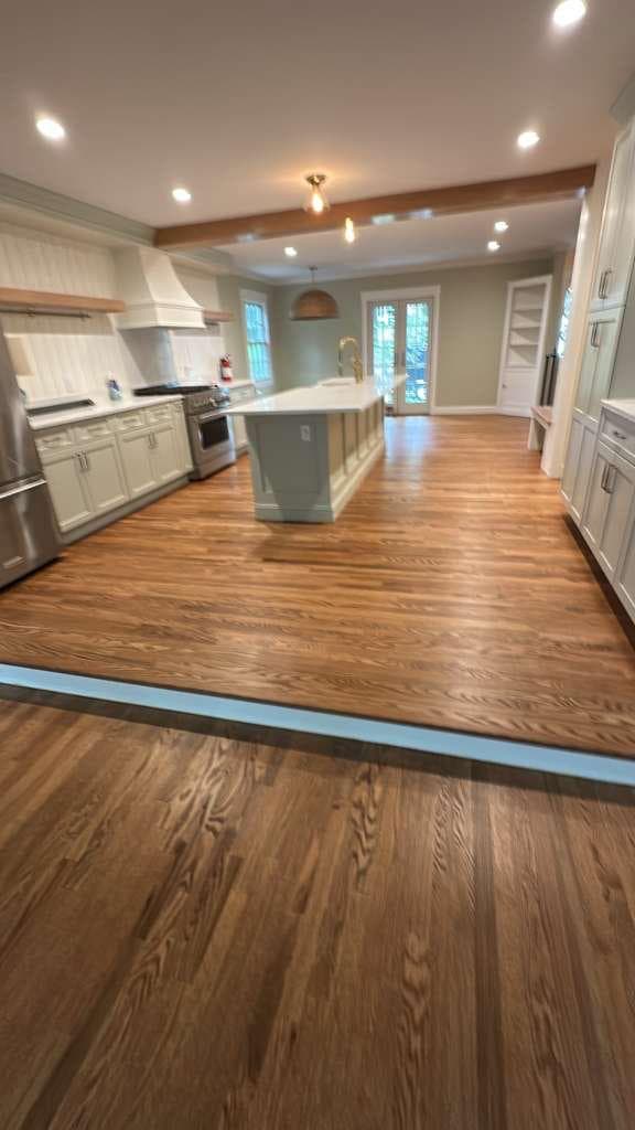 Refinished hardwood floor in a bright kitchen and dining area